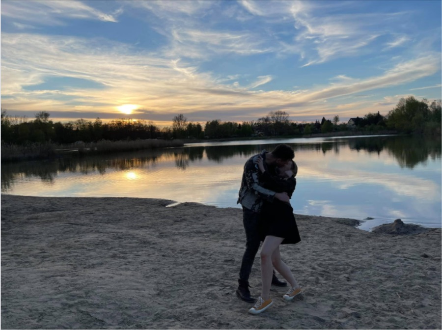 Paar umarmt sich bei Sonnenuntergang am See